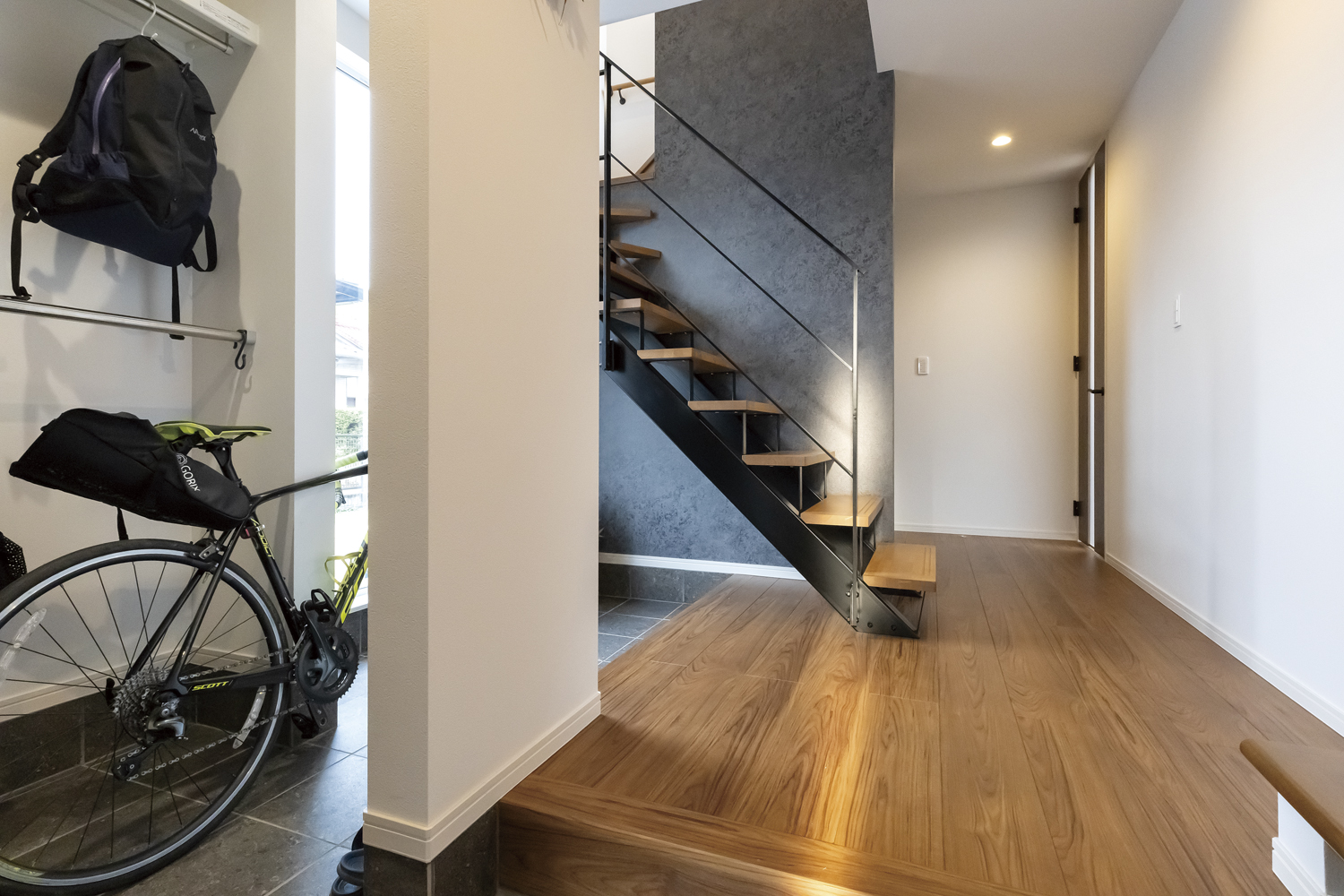 ブラックアイアンの手すりを使った玄関からのオープン階段